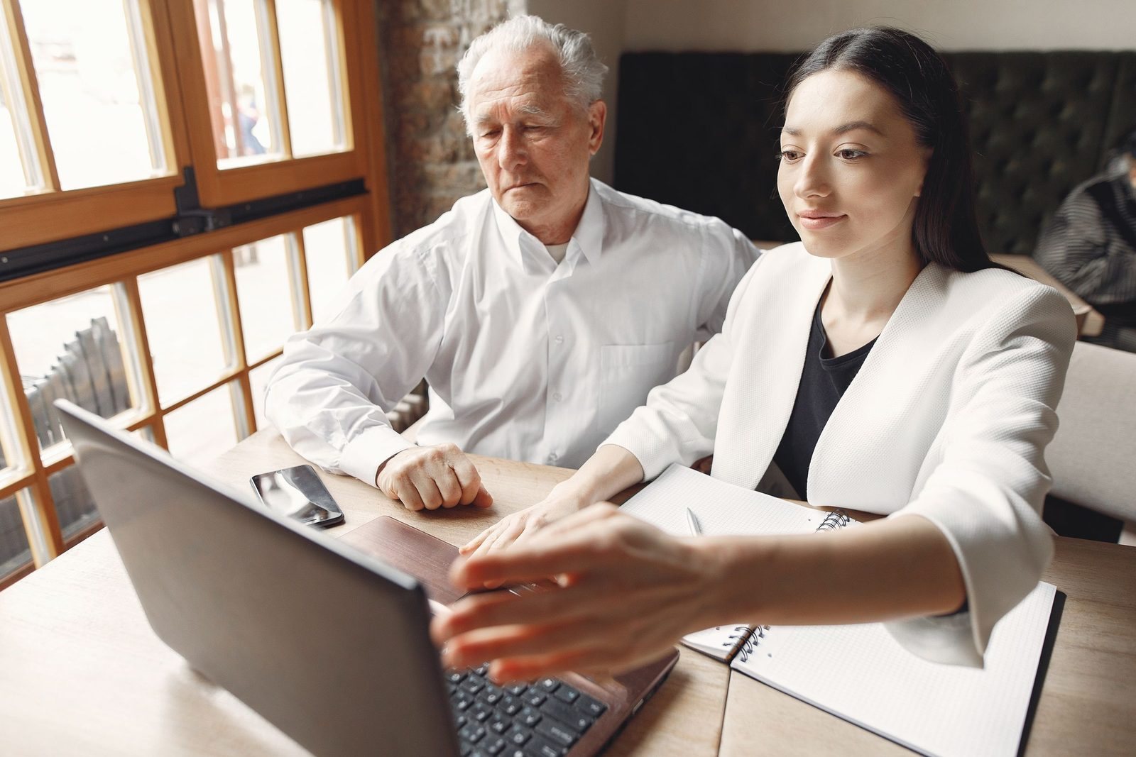 An experienced adviser working with a younger colleague