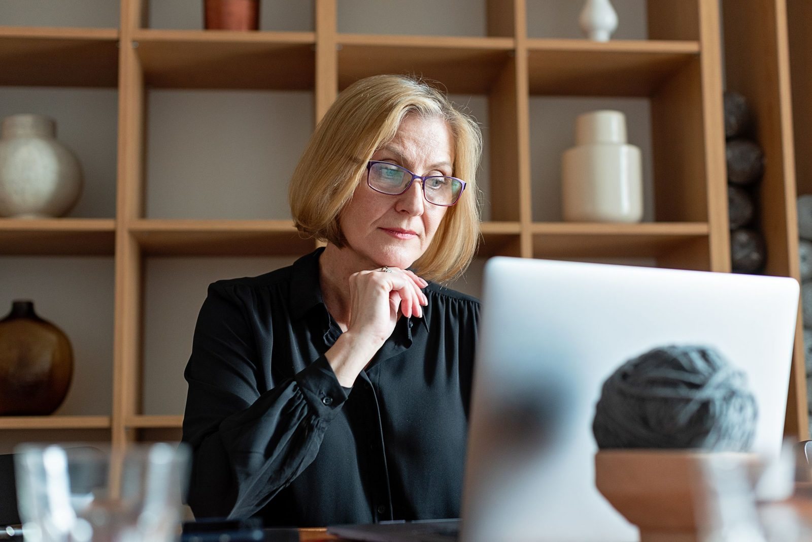 A principal thinking at her laptop