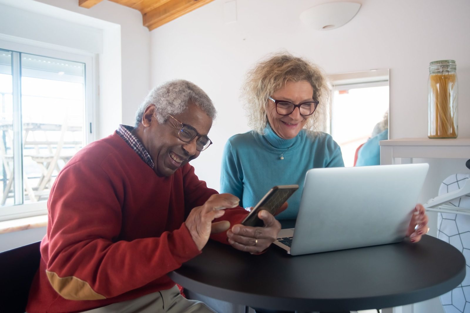 A retired couple looking at a laptop at home