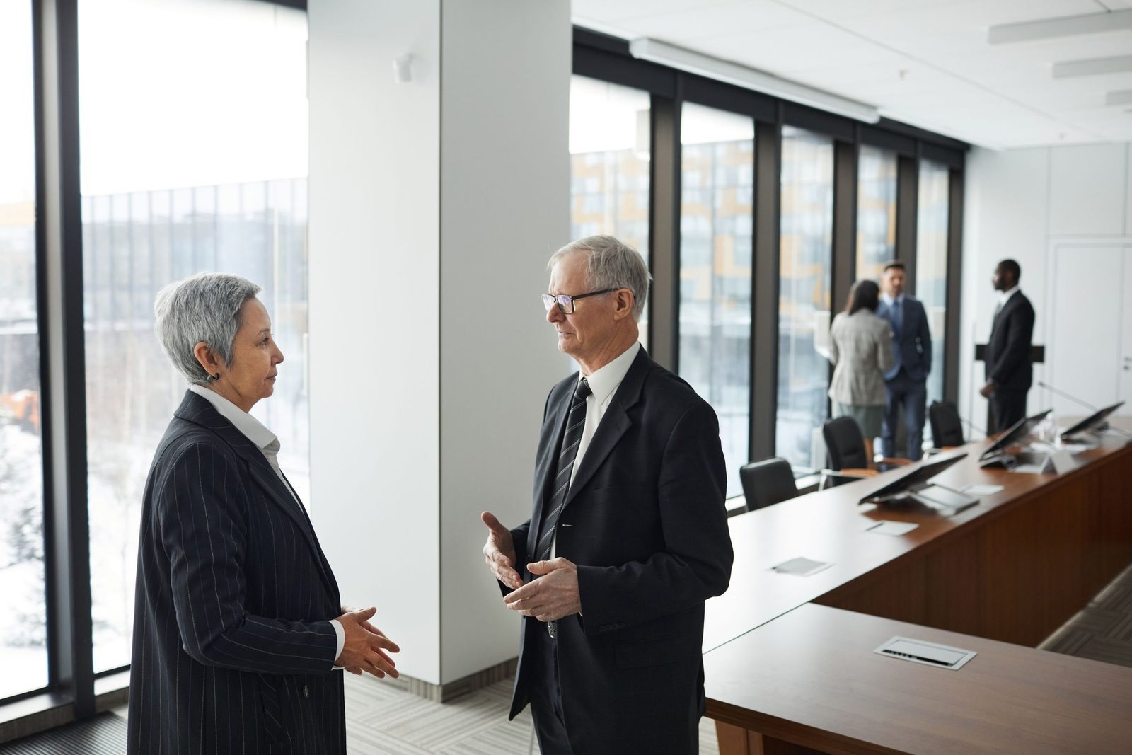 Two senior advisers reviewing papers at a meeting table